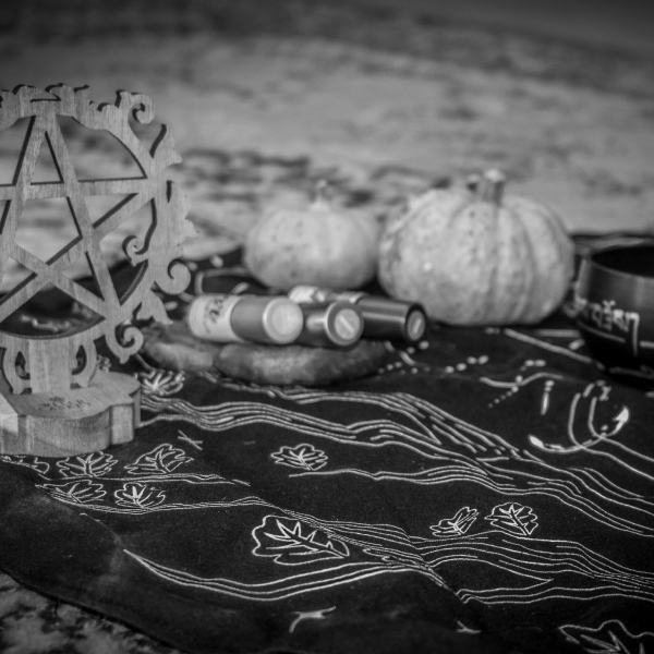 Sacred ceremony altar for spiritual wellness with singing bowl, essential oil blends for chakras and a pentacle for protection.