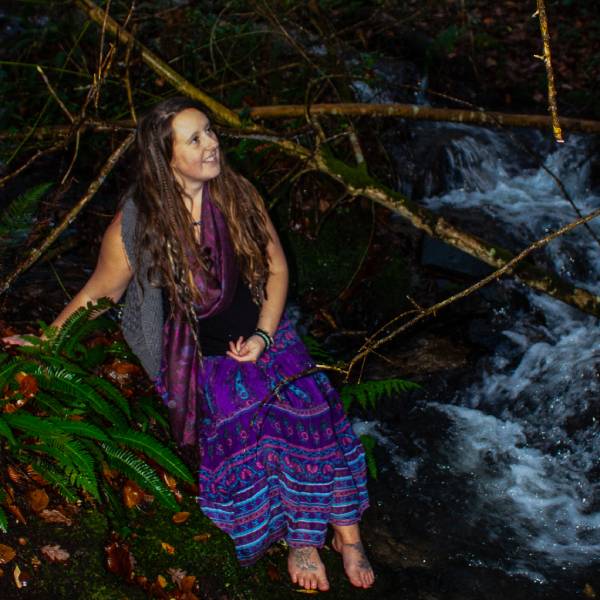 Massage therapist sitting in nature in Cornwall.